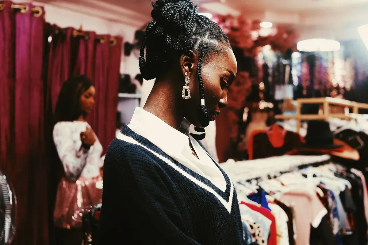 Une cliente choisit un vêtement dans une boutique de mode